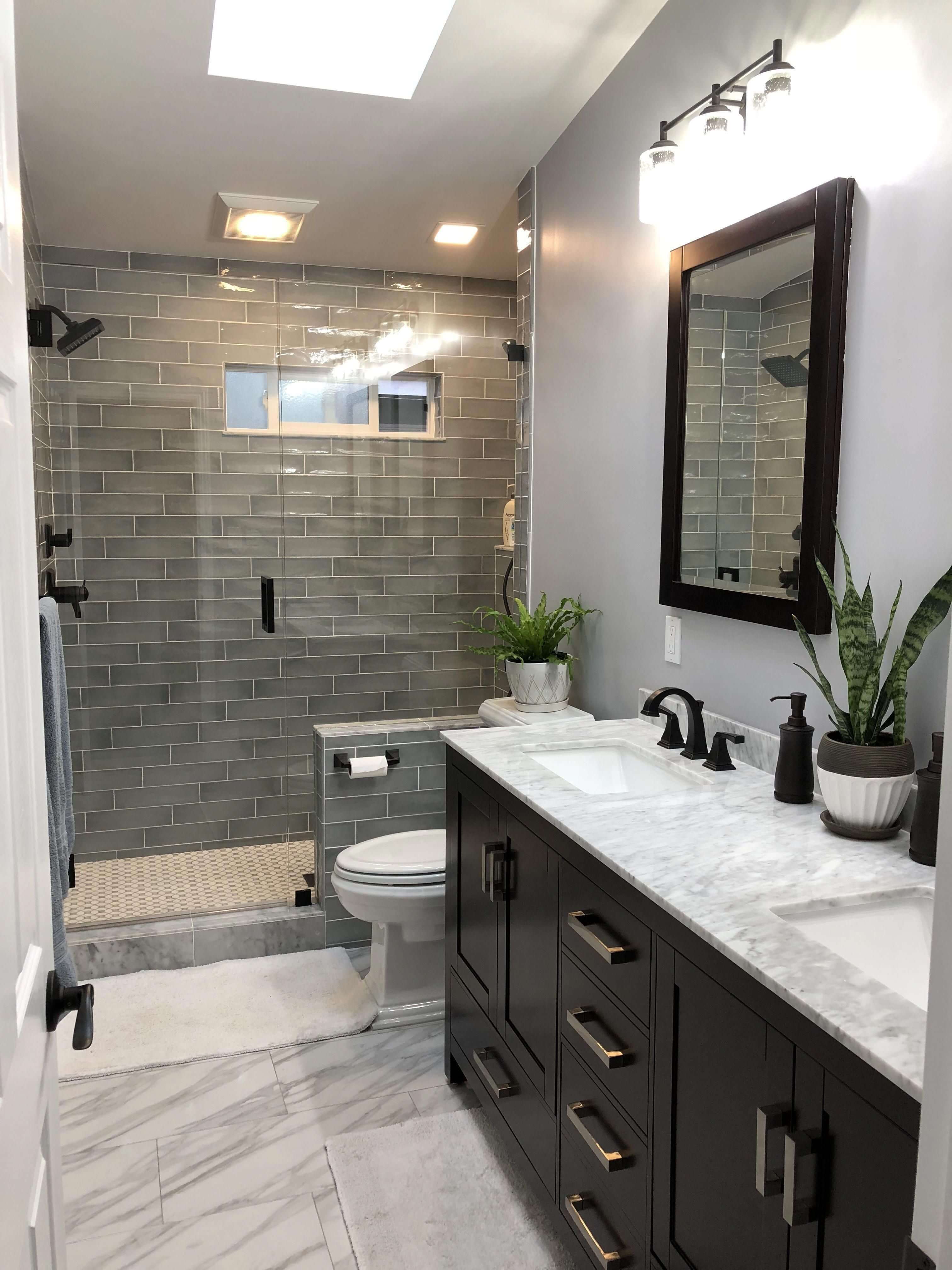 Sophisticated bathroom renovation completed by Zenith Builders showcasing an upscale walk-in shower with textured beige herringbone tiles, sleek black shower fixtures, and dual inset niches for amenities.